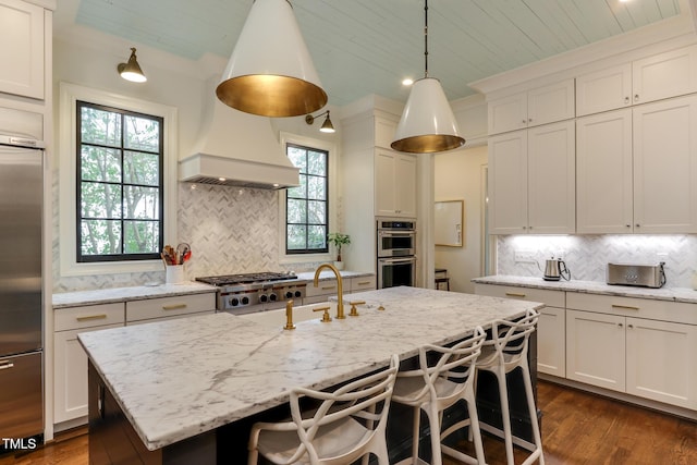 kitchen featuring lofted ceiling, dark wood-type flooring, appliances with stainless steel finishes, light stone countertops, and tasteful backsplash