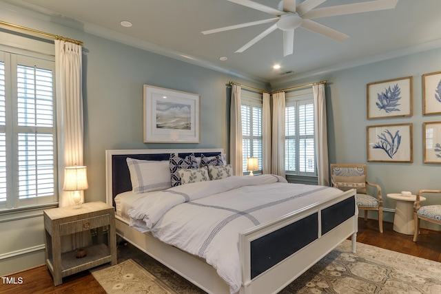 bedroom with multiple windows, ornamental molding, and wood finished floors