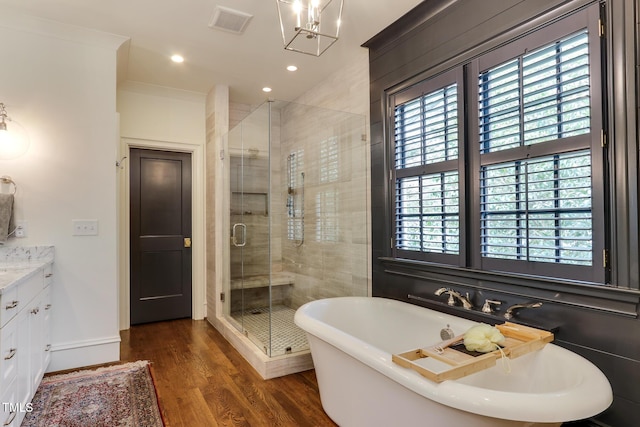 full bath with a soaking tub, visible vents, a stall shower, vanity, and wood finished floors