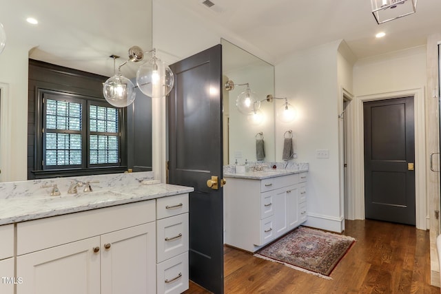 full bath with two vanities, visible vents, ornamental molding, a sink, and wood finished floors