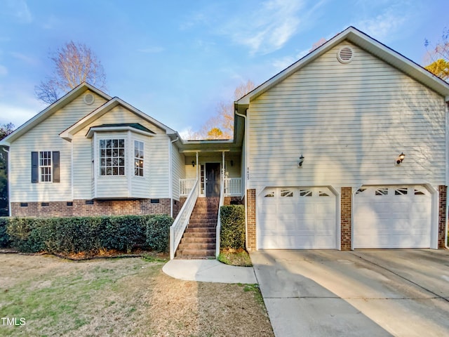 view of front of home featuring a porch, crawl space, driveway, and stairway