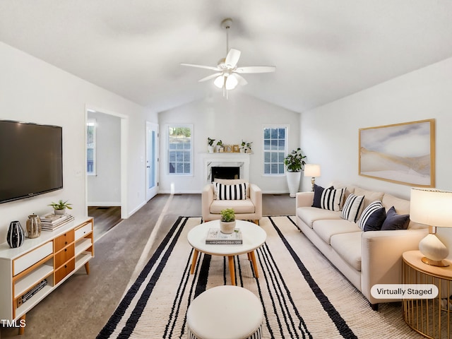 living area featuring lofted ceiling, ceiling fan, a fireplace, and baseboards