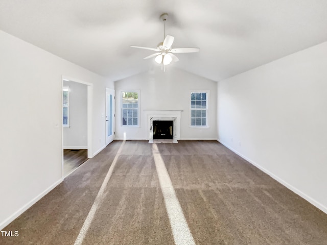 unfurnished living room with baseboards, lofted ceiling, ceiling fan, carpet flooring, and a fireplace