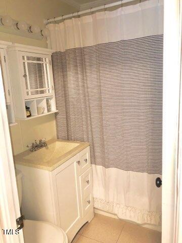 bathroom featuring curtained shower, vanity, toilet, and tile patterned floors