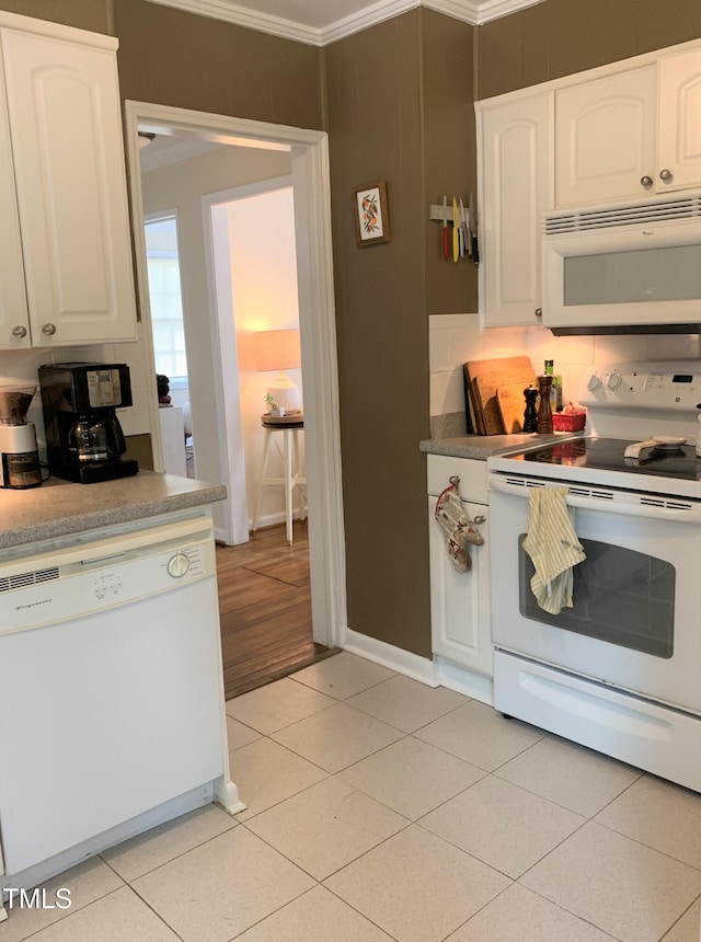 kitchen featuring ornamental molding, white appliances, light tile patterned floors, and white cabinets