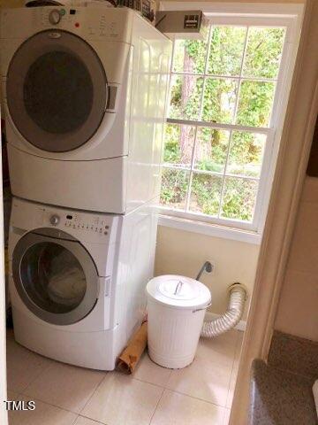 laundry room featuring stacked washer and dryer, laundry area, and tile patterned floors