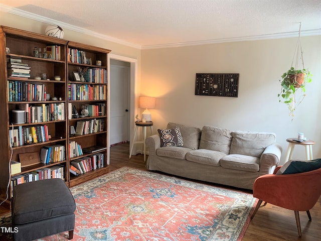 living room featuring a textured ceiling, ornamental molding, and wood finished floors