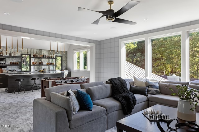 living area with a dry bar, ceiling fan, and carpet floors