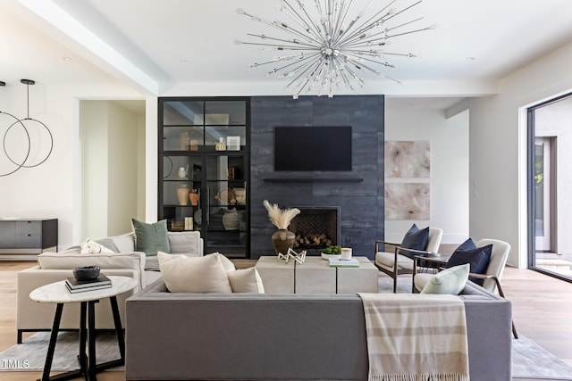 living area featuring a fireplace, an inviting chandelier, and wood finished floors