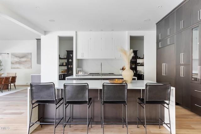 kitchen featuring a kitchen bar, light countertops, and light wood finished floors