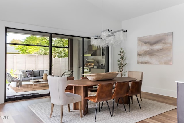 dining space with baseboards and wood finished floors