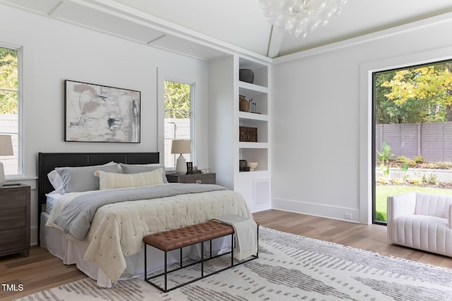 bedroom with a notable chandelier, baseboards, light wood-type flooring, and visible vents