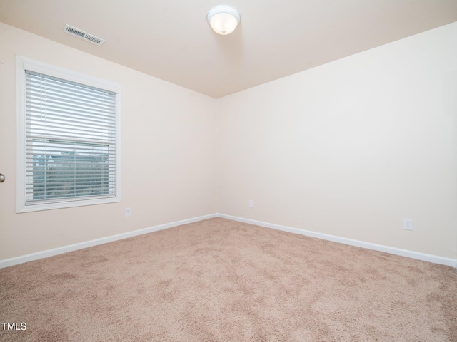 carpeted spare room featuring visible vents and baseboards