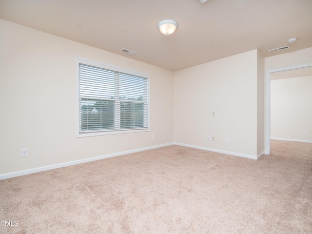 carpeted empty room featuring visible vents and baseboards