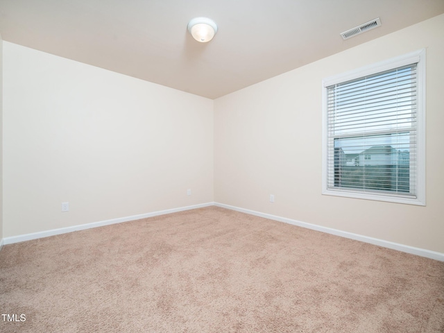 carpeted empty room with visible vents and baseboards