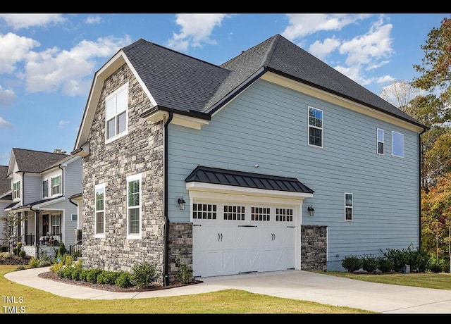 view of side of property featuring stone siding, a standing seam roof, metal roof, and an attached garage