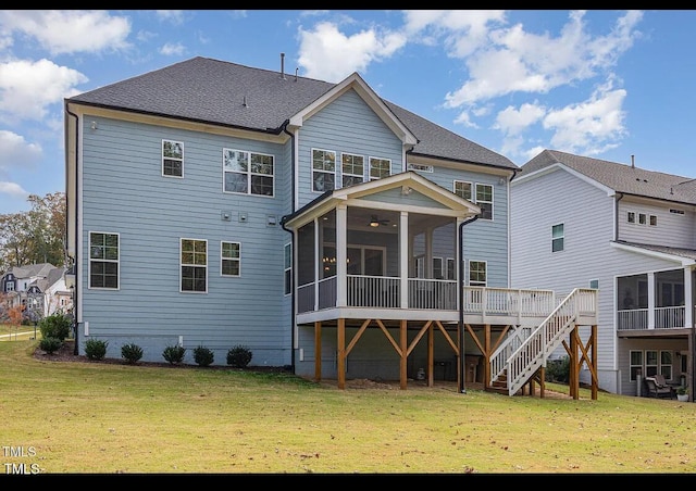 back of property with a shingled roof, a sunroom, a yard, and stairs