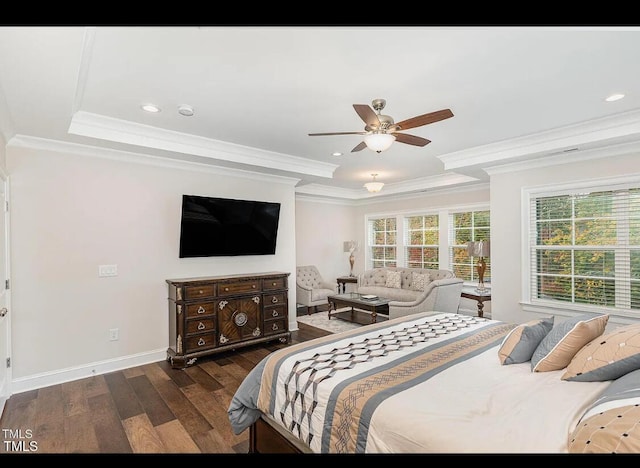 bedroom featuring baseboards, wood finished floors, a raised ceiling, and crown molding