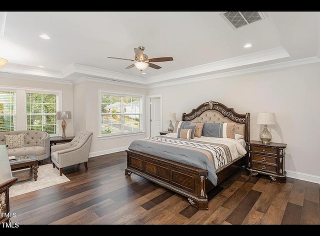 bedroom with a raised ceiling, visible vents, and wood finished floors