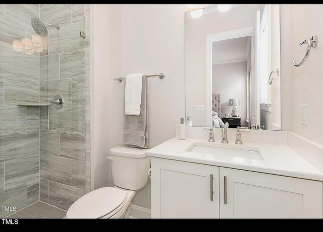 bathroom with toilet, ensuite bathroom, ornamental molding, a shower stall, and vanity