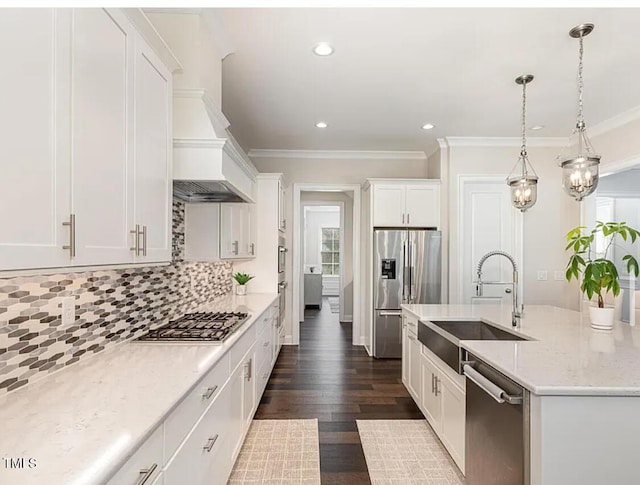 kitchen featuring dark wood-style flooring, tasteful backsplash, appliances with stainless steel finishes, white cabinets, and a sink