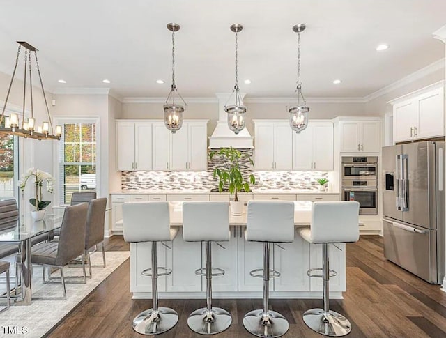 kitchen featuring dark wood-style floors, tasteful backsplash, appliances with stainless steel finishes, white cabinets, and a kitchen island