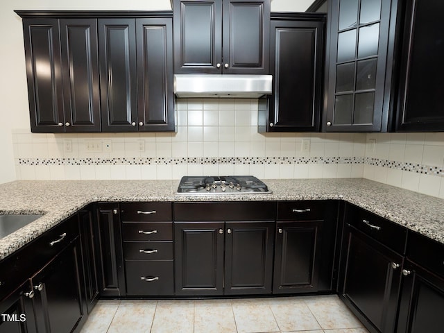 4137 Strendal Dr, Cary, NC 27519 - kitchen with stainless steel gas cooktop, backsplash, under cabinet range hood, and light stone counters