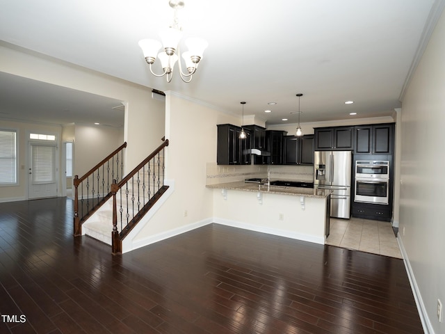 4137 Strendal Dr, Cary, NC 27519 - kitchen featuring baseboards, a peninsula, a kitchen breakfast bar, and stainless steel appliances