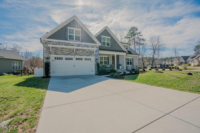 craftsman inspired home with a garage, concrete driveway, a front lawn, and fence