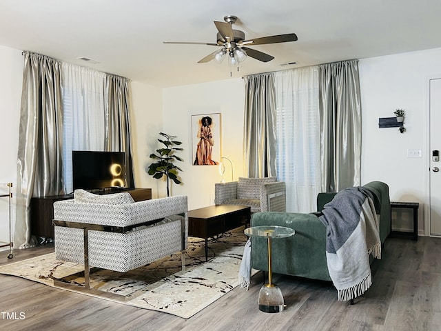 sitting room with visible vents, ceiling fan, and wood finished floors