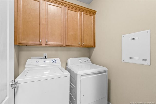 laundry room featuring independent washer and dryer and cabinet space