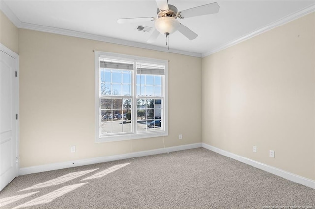 carpeted spare room with visible vents, crown molding, baseboards, and ceiling fan