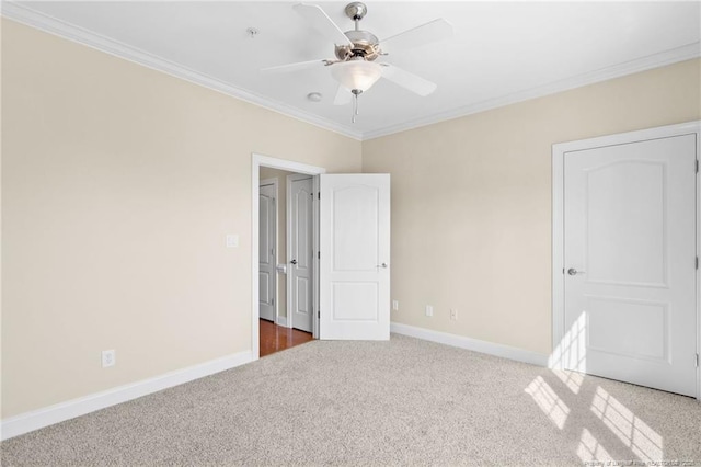 unfurnished bedroom featuring carpet, crown molding, baseboards, and ceiling fan