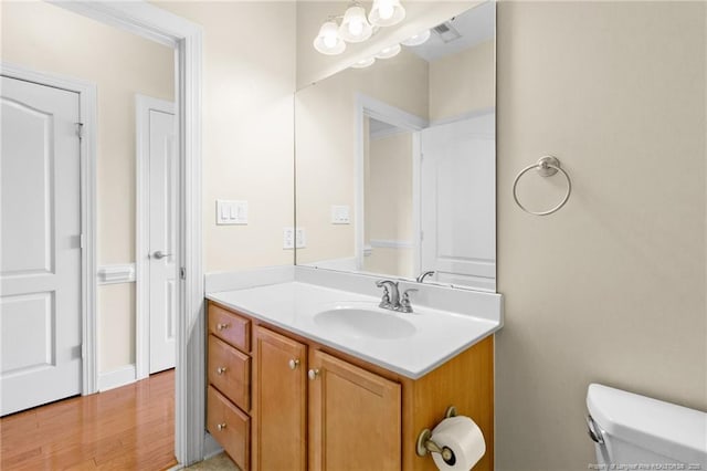 bathroom featuring wood finished floors, vanity, and toilet