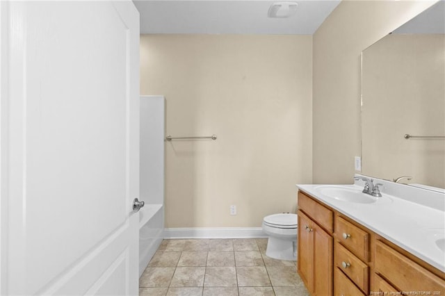 bathroom featuring a bathtub, toilet, a sink, tile patterned flooring, and baseboards