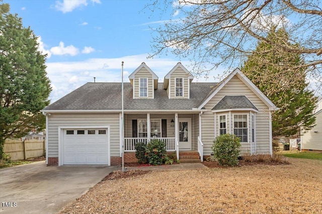 cape cod house featuring driveway, a shingled roof, an attached garage, fence, and a porch