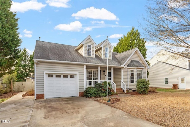 cape cod house featuring a garage, covered porch, driveway, and roof with shingles