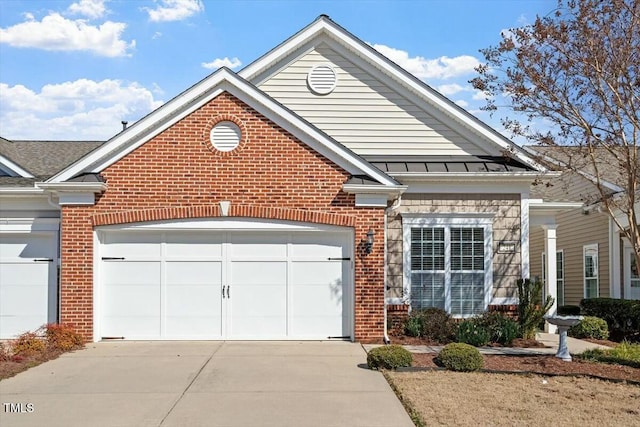 view of front of house with a standing seam roof, a garage, brick siding, and driveway