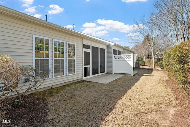 rear view of house featuring central AC unit, fence, and a sunroom