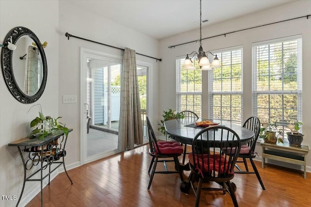 dining area featuring plenty of natural light, wood finished floors, visible vents, and a chandelier