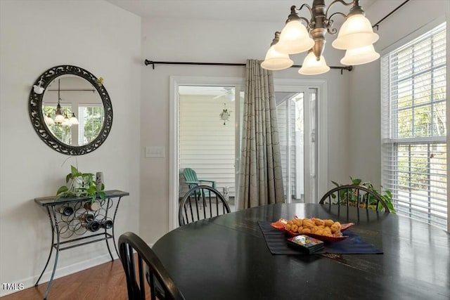 dining room with a notable chandelier, baseboards, and wood finished floors