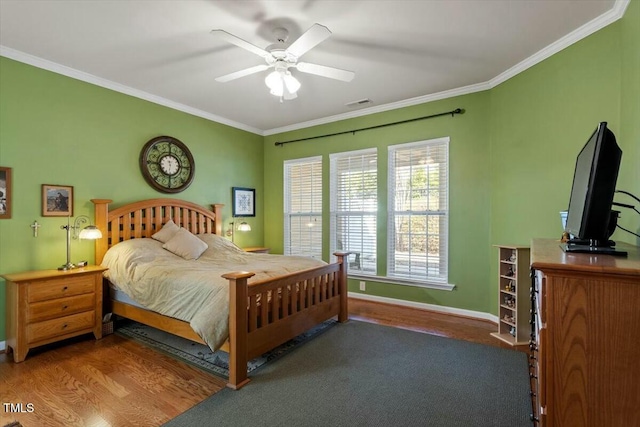 bedroom featuring visible vents, wood finished floors, and ornamental molding