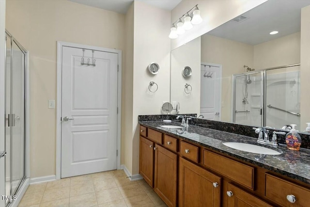 full bath with a sink, a stall shower, and tile patterned floors