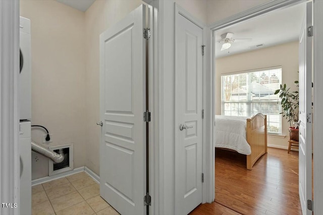 hallway featuring visible vents, baseboards, and light wood-style flooring