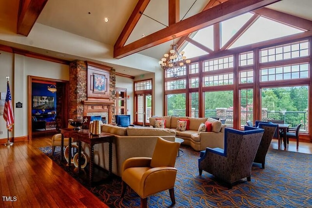 living area with beam ceiling, high vaulted ceiling, hardwood / wood-style flooring, an inviting chandelier, and a fireplace