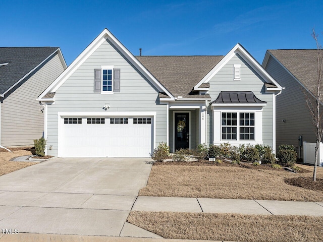 traditional home featuring driveway, a standing seam roof, metal roof, and roof with shingles