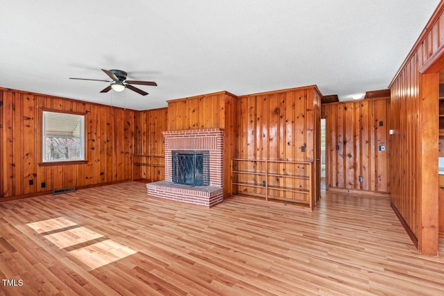 unfurnished living room with visible vents, baseboards, light wood-style flooring, ceiling fan, and a fireplace