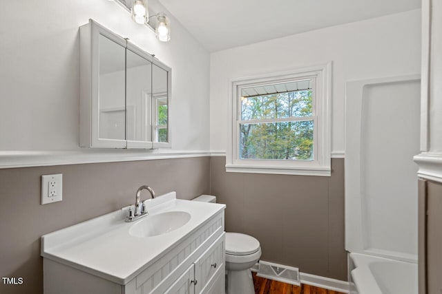 bathroom featuring visible vents, toilet, vanity, a tub, and walk in shower