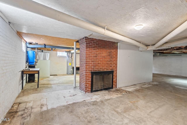 below grade area featuring brick wall, a fireplace, and electric water heater