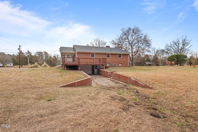 back of house with a garage, a yard, driveway, and a wooden deck